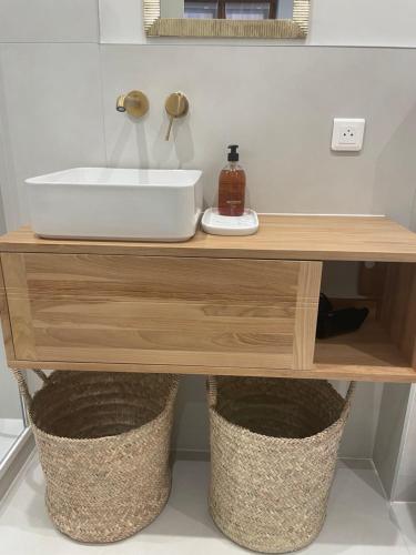 a bathroom counter with a sink and two baskets at L'Adresse Studio Rempart sud - centre historique Eguisheim in Eguisheim