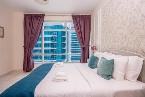 ein Schlafzimmer mit einem großen Bett mit lila Vorhängen und einem Fenster in der Unterkunft Vacay Lettings - Loft Downtown Dubai in Dubai