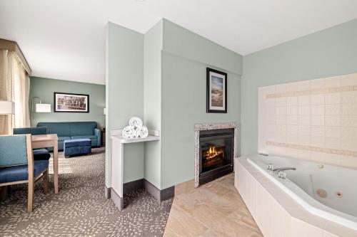 ein Badezimmer mit einer Badewanne und ein Wohnzimmer mit einem Kamin in der Unterkunft La Quinta by Wyndham Newport in Newport