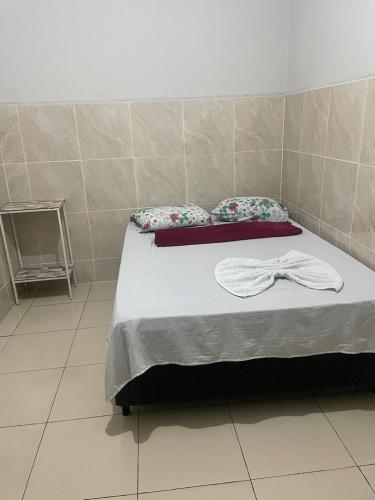 a bedroom with a bed with a bow tie on it at Hotel B&B in Santa Inês