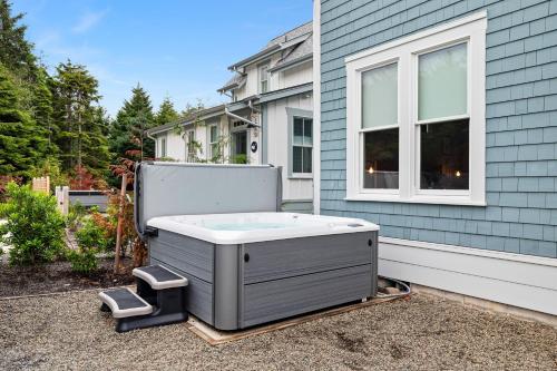 a hot tub sitting outside of a house at Dogwood Cottage by Seabrook Hospitality in Pacific Beach