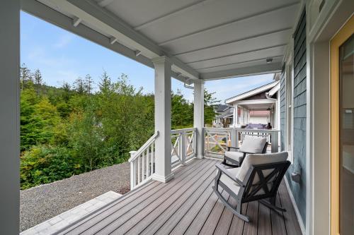 a porch with two chairs on a house at Dogwood Cottage by Seabrook Hospitality in Pacific Beach