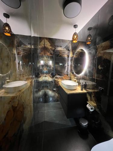 a bathroom with two sinks and two mirrors at Willa przy Krupówkach in Zakopane