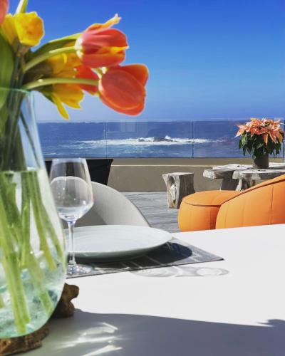 un vase de fleurs assis sur une table avec une fenêtre dans l'établissement La Maison sur la Plage, à Calcatoggio
