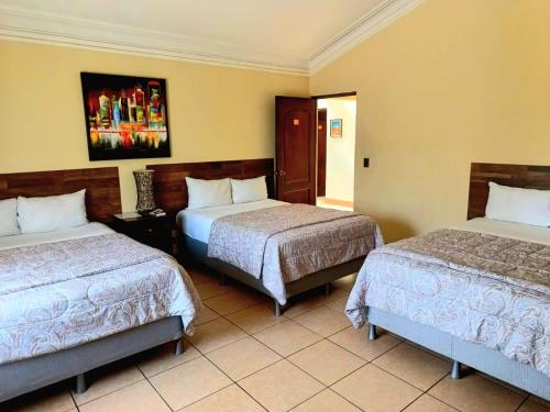 una habitación de hotel con 2 camas en una habitación en Hotel Don Felipe Aeropuerto, en Guatemala