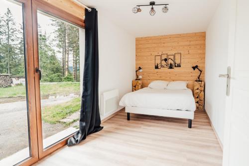 une chambre avec un lit et une fenêtre dans l'établissement La maison du Xetté, à Gérardmer