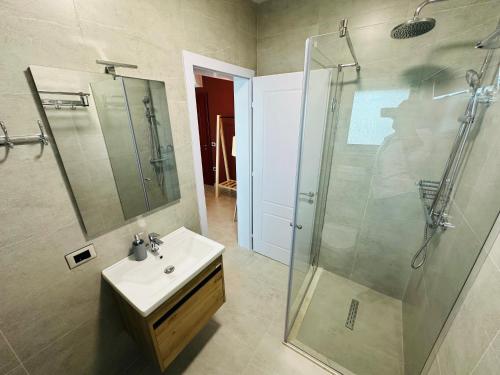 a bathroom with a sink and a glass shower at STAY-FIVE rooms & apartments in Shkodër