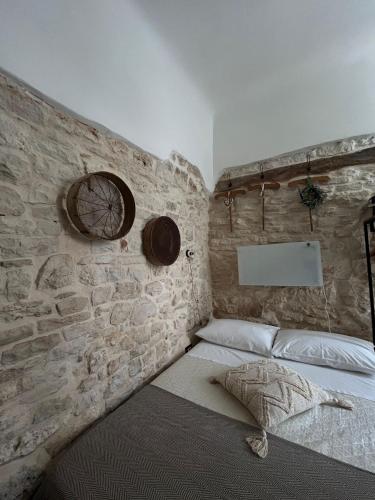 a bed in a room with a stone wall at Casa Giulia in Martina Franca