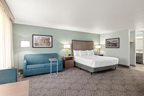 a hotel room with a bed and a blue chair at La Quinta by Wyndham Newport in Newport