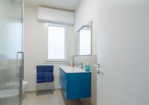 a bathroom with a blue sink and a mirror at VillaBaci sul Mare - Spiaggia privata in Rimini
