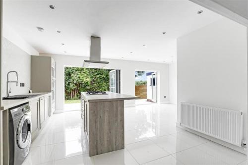 a white kitchen with a washer and dryer in it at Brand New 4 Bed Deluxe Modern Villa - Sleeps 9 - Private Parking & Garden in Nottingham