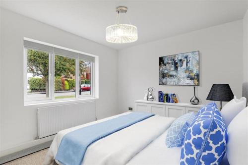 a white bedroom with a bed and a window at Brand New 4 Bed Deluxe Modern Villa - Sleeps 9 - Private Parking & Garden in Nottingham