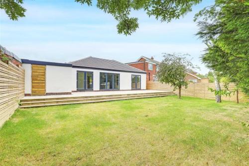 a home with a lawn in front of a house at Brand New 4 Bed Deluxe Modern Villa - Sleeps 9 - Private Parking & Garden in Nottingham