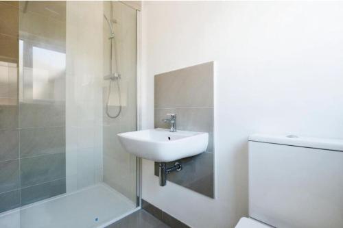 a bathroom with a sink and a shower and a toilet at Brand New 4 Bed Deluxe Modern Villa - Sleeps 9 - Private Parking & Garden in Nottingham