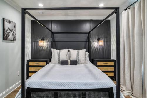 a bedroom with a black canopy bed with two night stands at Lincolnville Nook in St. Augustine