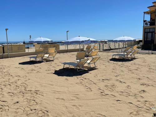 a group of chairs and umbrellas on a beach at VillaBaci sul Mare - Spiaggia privata in Rimini