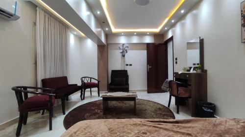 アスユートにあるفندق أجياد Agyad Hotelのベッド、椅子、テーブルが備わる客室です。