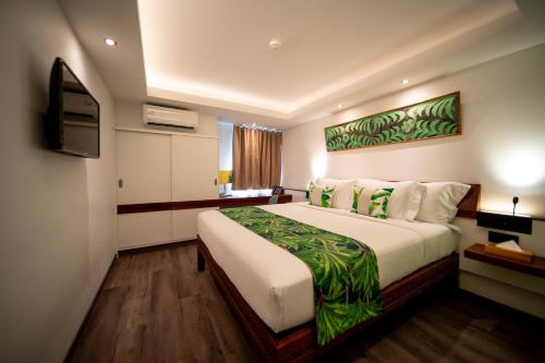 a hotel room with a large bed and a television at Maitai Express Tahiti in Papeete