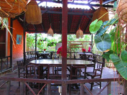a dining room with tables and chairs and plants at Hostería Ecológica El Faro in Salinas