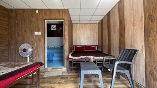Zimmer mit 2 Betten, einem Tisch und Stühlen in der Unterkunft Rishikesh Riverside Camping By PT in Rishikesh