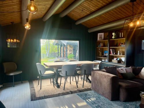 jadalnia ze stołem, krzesłami i kanapą w obiekcie Cosy and Quiet Cabin with Sauna close to Hemsedal w mieście Lykkja