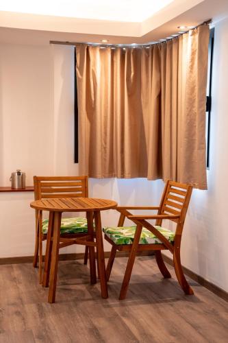 two wooden chairs and a wooden table and bench at Maitai Express Tahiti in Papeete