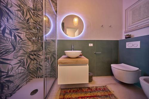 a bathroom with a sink and a toilet and a mirror at Benaco Hause 3 in Brenzone sul Garda