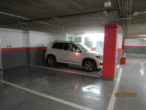 a small white car parked in a parking garage at P&C Areny in Canillo