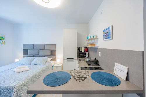 een slaapkamer met een bed en een tafel met blauwe matten bij Guest House Arsenal Accommodation in Zadar