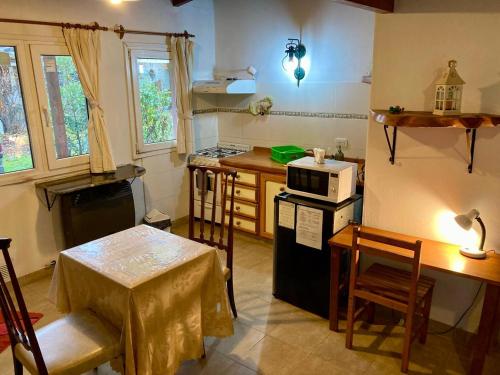 una cucina con un tavolo e una stufa forno superiore di Sabrosur Departamentos a El Bolsón