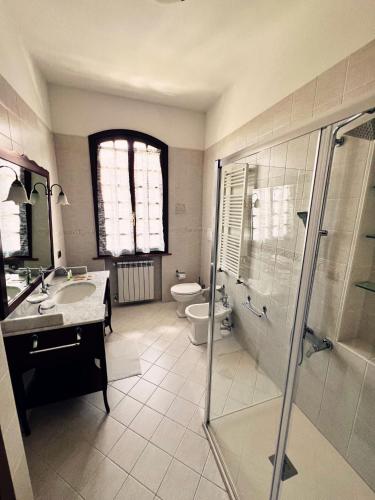 uma casa de banho com um chuveiro, um WC e um lavatório. em Prima Luce em Peschiera del Garda