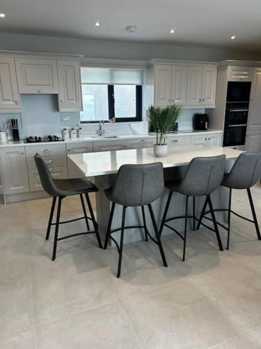 a kitchen with a table and chairs in it at Kells Ocean View Luxury Retreat in Kilkeehagh