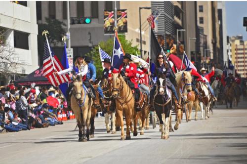 a group of people riding horses in a parade at The King's Retreat II in Houston