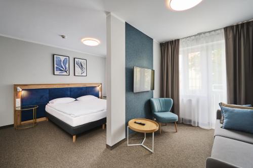 um quarto de hotel com uma cama e um sofá em Halo Toruń em Toruń