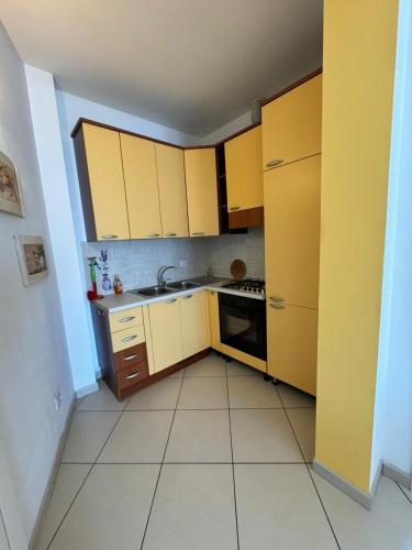 a small kitchen with yellow cabinets and a sink at La casa di Glenda ospedale in Terni