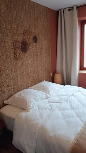 une chambre avec un lit blanc et une fenêtre dans l'établissement Le Physalis gîte tout confort, à Orbey