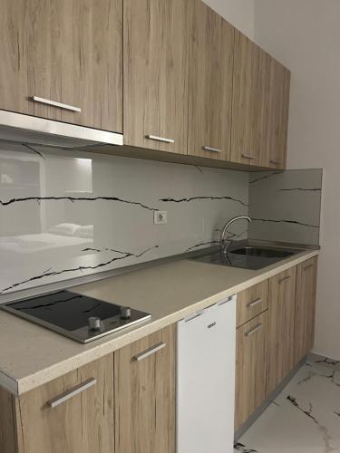 a kitchen with wooden cabinets and a counter top at Xhefri's Apartments in Vlorë