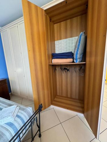 a room with a bed and a wooden closet at La casa di Glenda ospedale in Terni