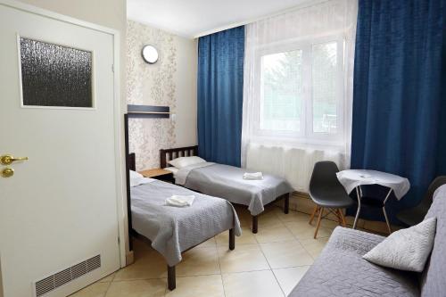 een hotelkamer met 2 bedden en een raam bij Promenada in Węgierska Górka
