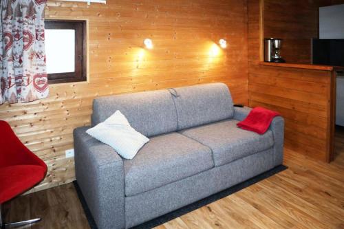 - un salon avec un canapé gris et 2 oreillers dans l'établissement Residence Le 1650 - Studio pour 2 personnes cœur de station des Orres 1650 MAE-5821, aux Orres