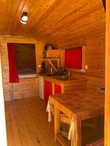 - une cuisine avec une table dans une cabane en bois dans l'établissement Charmante roulotte, à Collonges-lès-Premières