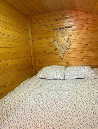 une chambre avec un lit dans une cabane en bois dans l'établissement Charmante roulotte, à Collonges-lès-Premières