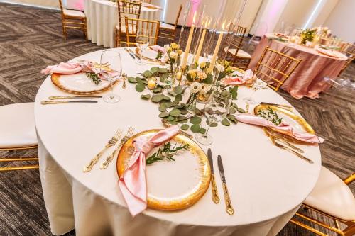 a white table with pink and gold plates and flowers at Hyatt Place Milwaukee Downtown in Milwaukee