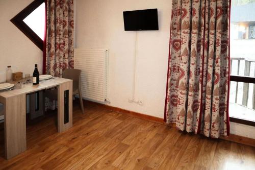 Cette chambre dispose d'un bureau et d'une fenêtre avec une télévision. dans l'établissement Residence Le 1650 - Studio pour 2 personnes cœur de station des Orres 1650 MAE-5841, aux Orres