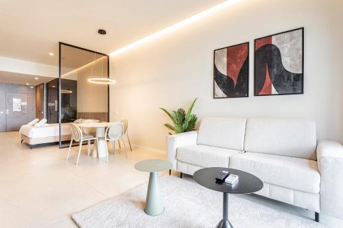 a living room with a white couch and a table at North Station PEN-SUITES in Valencia