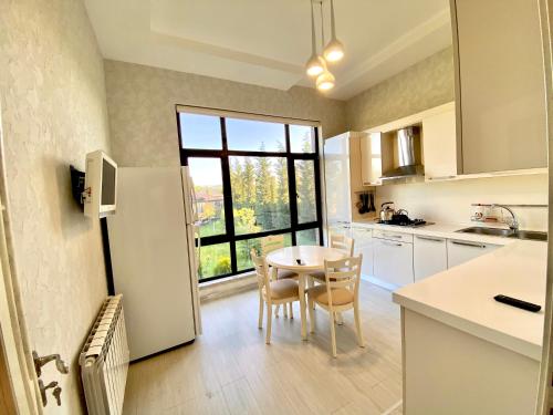 a kitchen with a table and chairs and a window at Villa Lux in Quba in Quba
