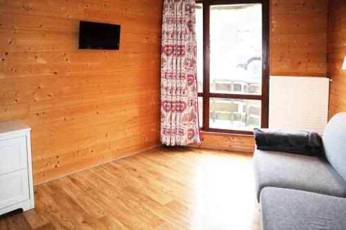 un salon avec un canapé et une fenêtre dans l'établissement Residence Le 1650 - Studio pour 3 personnes cœur de station des Orres 1650 MAE-5851, aux Orres