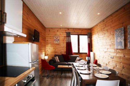 une cuisine et un salon avec une table et un canapé dans l'établissement Residence Le 1650 - Bel appartement pour 10 personnes cœur de station MAE-5861, aux Orres