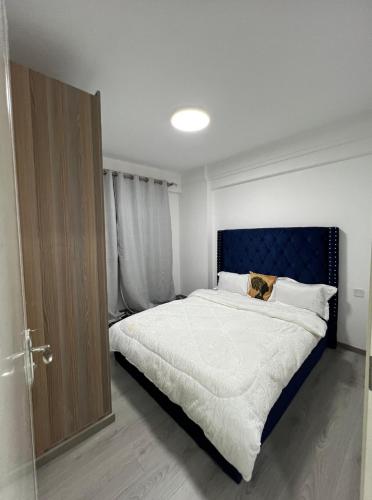 una camera da letto con un letto grande con testiera blu di B301 3bedroom apartment at Goldpark Homes Kilimani a Nairobi