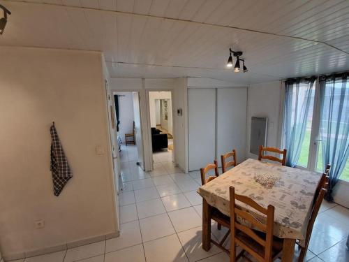 une salle à manger et une cuisine avec une table et des chaises dans l'établissement maison individuelle bassin arcachon, au Teich